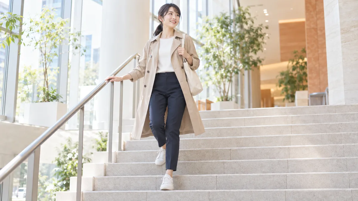 上りはエスカレーターに任せ、下りだけ階段を使う。手すりに軽く手を添えて、一段ずつ下りる女性